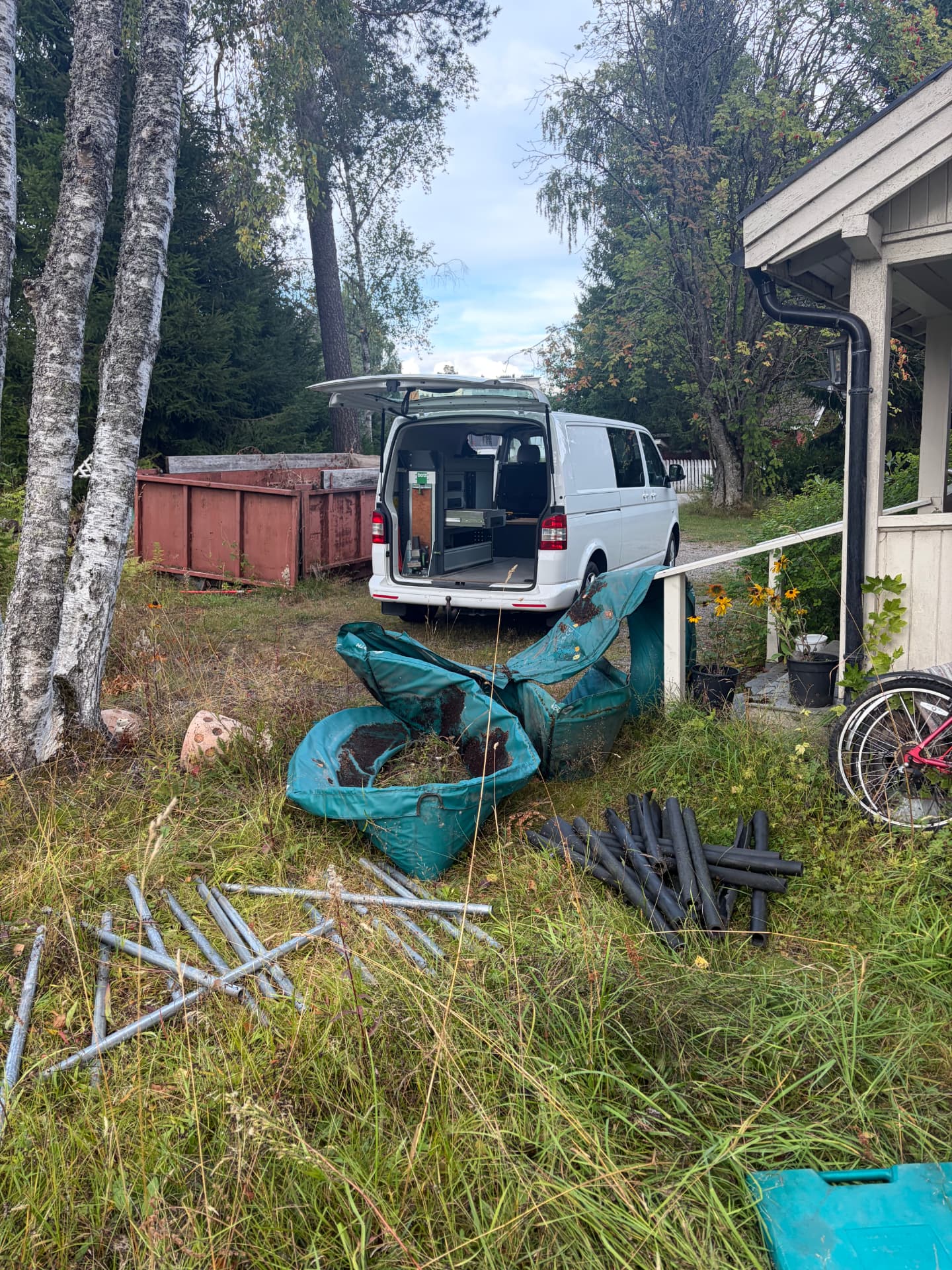 Varebil på hageryddeoppdrag med hagesekker, rør og metall sortert for levering